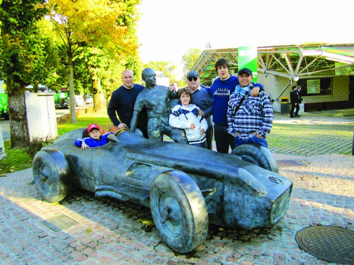 Imagen LA FAMILIA completa junto con la escultura que se luce en el ingreso al mítico Monza y resalta la grandeza de Chueco Fangio en el mundo.