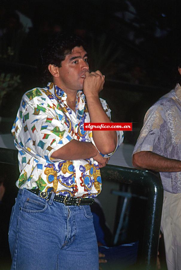 Imagen ¡Que ganas de jugar! Maradona se come las uñas mientras los que corren y juegan son otros.